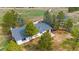 An aerial view shows the home with its deck and surrounding mature trees at 1604 Lisbon Dr, Parker, CO 80138