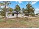 Backyard of home with lush trees and a deck, blending nature and comfort at 1604 Lisbon Dr, Parker, CO 80138