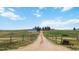 Long driveway leading to a beautiful home, barn, and stunning scenery beyond at 1604 Lisbon Dr, Parker, CO 80138