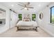Bright bedroom with a large bed, bench, ceiling fan, and windows offering natural light and views at 3235 E Easter Pl, Centennial, CO 80122