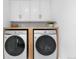 Functional laundry room with white cabinets, modern washer and dryer, and wood countertop at 3235 E Easter Pl, Centennial, CO 80122
