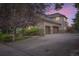 Exterior view of a stucco home featuring a large driveway and a two-car garage with stone accents at 714 Skywalker Pt, Lafayette, CO 80026