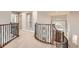 Hallway with metal and wood banister, mirror, and views of the entry way at 714 Skywalker Pt, Lafayette, CO 80026