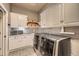 Laundry room features large washer dryer, tile floor, and built in shelving at 714 Skywalker Pt, Lafayette, CO 80026