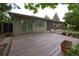 Back deck of home overlooks yard, exterior view of siding and brick with nice landscaping at 7140 S Uinta St, Centennial, CO 80112