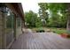 View of the wooden back deck with beautiful backyard landscaping and mature trees at 7140 S Uinta St, Centennial, CO 80112