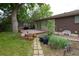 View of back deck, brick and siding home, mature trees and landscaping at 7140 S Uinta St, Centennial, CO 80112