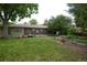 Brick and siding home with mature trees, lawn, and outdoor landscaping at 7140 S Uinta St, Centennial, CO 80112