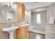 Bathroom featuring double sinks, natural wood cabinets, decorative mirrors, and glass shower at 33633 Elk Run, Evergreen, CO 80439