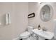 Bright half bath featuring a pedestal sink, toilet and a large mirror at 33633 Elk Run, Evergreen, CO 80439