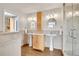Bathroom with double sinks, mirrors, and a walk-in glass shower at 33633 Elk Run, Evergreen, CO 80439