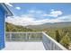 Breathtaking mountain views from this spacious deck with white railing and blue exterior walls at 33633 Elk Run, Evergreen, CO 80439