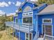 Charming exterior elevation with blue siding, decks, and mountain views, showcasing curb appeal at 33633 Elk Run, Evergreen, CO 80439