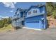 Exterior shows blue house with multiple decks, a two-car garage, and a charming mountainside at 33633 Elk Run, Evergreen, CO 80439