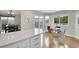 Well-lit open kitchen featuring a breakfast nook, island with bar stools, and white cabinets at 33633 Elk Run, Evergreen, CO 80439