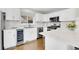 Modern kitchen with white cabinets, marble countertops, stainless steel appliances, and hardwood floors at 33633 Elk Run, Evergreen, CO 80439