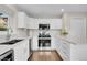 Bright kitchen featuring white cabinets, stainless steel appliances, and spacious countertops at 33633 Elk Run, Evergreen, CO 80439