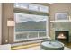 Close up view of the living room fireplace, large windows, and exterior forest view at 33633 Elk Run, Evergreen, CO 80439