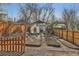 View of backyard with fence, greenhouse, garden beds and mature trees at 2421 Hooker St, Denver, CO 80211