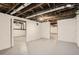 Unfinished basement space with exposed beams and painted walls and floors at 2421 Hooker St, Denver, CO 80211