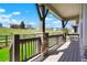Covered back porch featuring stone pillars, wooden railings, and views of the lush backyard at 8052 Mount Kataka St, Littleton, CO 80125