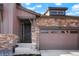 Inviting exterior with a stylish front door, stone accents, manicured landscaping and an attached two-car garage at 8052 Mount Kataka St, Littleton, CO 80125