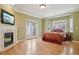 Bright bedroom with fireplace, TV, and doors to the outdoor space at 5530 E 6Th Avenue Pkwy, Denver, CO 80220