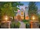 Charming Tudor home with a brick walkway, manicured lawn, and beautifully lit exterior at 5530 E 6Th Avenue Pkwy, Denver, CO 80220