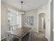 Bright dining area offers a modern chandelier, neutral decor, and a sliding glass door for indoor-outdoor living at 5726 N Genoa Way # 201, Aurora, CO 80019