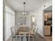 Elegant dining room features a modern chandelier, stylish wall decor, and sliding glass door that leads to balcony at 5726 N Genoa Way # 201, Aurora, CO 80019