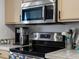 Modern stainless steel microwave and stove with countertops at 5726 N Genoa Way # 201, Aurora, CO 80019