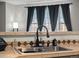 Close-up of kitchen sink and faucet with custom countertops and backsplash at 5726 N Genoa Way # 201, Aurora, CO 80019