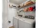 Convenient laundry room with washer, dryer, and shelving for storage at 5726 N Genoa Way # 201, Aurora, CO 80019
