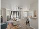 Bright living room boasts a ceiling fan, fireplace, a large window with stylish curtains, and an open floor plan at 5726 N Genoa Way # 201, Aurora, CO 80019