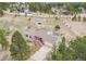 Aerial view of a charming gray single-Gathering home with a barn, shed, and mature trees at 1233 Starling Ln, Elizabeth, CO 80107