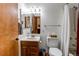 Traditional bathroom features wood vanity, framed mirror, medicine cabinet, and white tile bath with curtain at 1233 Starling Ln, Elizabeth, CO 80107