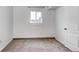 This bedroom features light carpet, a window, and a white door at 1233 Starling Ln, Elizabeth, CO 80107