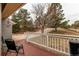 Cozy covered front porch with seating, offering a serene outdoor space and views of the treed landscape at 1233 Starling Ln, Elizabeth, CO 80107