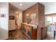 Hallway boasts a brick accent wall and leads to the living room, with wood floors and neutral decor at 1233 Starling Ln, Elizabeth, CO 80107