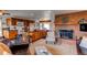 Open kitchen with a large central island, wooden cabinets, and stainless steel appliances with brick fire place at 1233 Starling Ln, Elizabeth, CO 80107