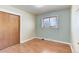 Bedroom with hardwood floors, window with blinds, and painted accent wall at 4755 S Irving St, Englewood, CO 80110