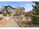 Landscaped backyard with stone accents, wooden stairs to deck, and inviting outdoor space at 6705 S Catawba Way, Aurora, CO 80016