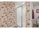 Bathroom with a glass shower, toilet, accent wallpaper, and neutral floors at 6705 S Catawba Way, Aurora, CO 80016