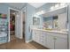 Well-lit bathroom featuring a double vanity with marble countertops and access to a walk-in closet at 6705 S Catawba Way, Aurora, CO 80016