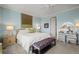 Serene bedroom features a plush bed, sitting bench, and vanity with ample natural light at 6705 S Catawba Way, Aurora, CO 80016