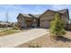 Charming home featuring a well-kept lawn, concrete driveway, and a mix of stone and siding exterior at 6705 S Catawba Way, Aurora, CO 80016
