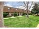 View of a row of brick townhouses with landscaped lawns and mature trees at 13017 W 20Th Ave, Golden, CO 80401