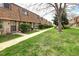 View of a row of brick townhouses with landscaped lawns and mature trees at 13017 W 20Th Ave, Golden, CO 80401