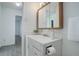 This bathroom features a white vanity with a wood-framed mirror and neutral paint and flooring at 3164 S Wheeling Way # 101, Aurora, CO 80014