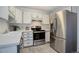 Kitchen with stainless steel refrigerator and range, gray vinyl floors and white cabinets at 3164 S Wheeling Way # 101, Aurora, CO 80014